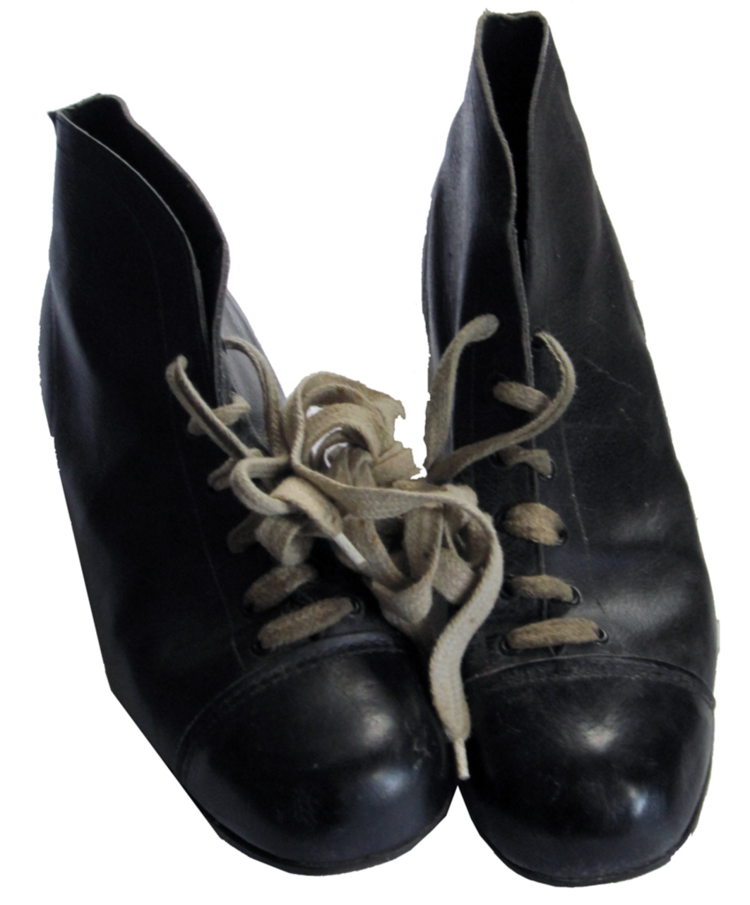 A pair of worn black leather lace-up boots with rounded toes and high ankles. The boots are scuffed, especially on the toe caps, showing signs of age and use. The laces are light-coloured and appear slightly frayed, loosely tied in a knot.